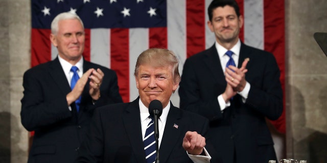President Donald Trump, flanked by Vice President Mike Pence and House Speaker Paul Ryan of Wis., gestures on Capitol Hill in Washington, Tuesday, Feb. 28, 2017, before his address to a joint session of Congress. (Jim Lo Scalzo/Pool Image via AP)