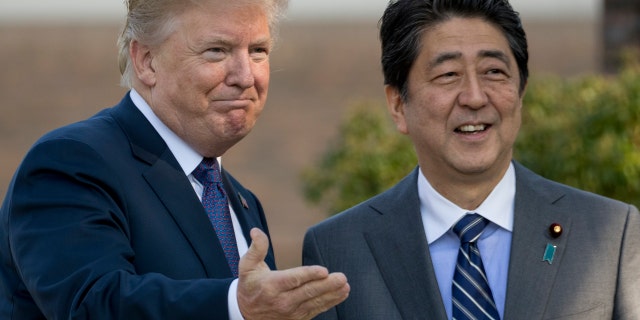 U.S. President Donald Trump and Japan's Prime Minister Shinzo Abe greet one another at Kasumigaseki Country Club outside Tokyo, Nov. 5, 2017.