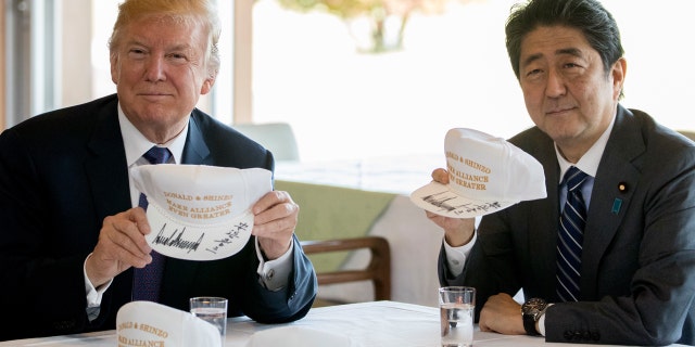 U.S. President Donald Trump and Japan's Prime Minister Shinzo Abe display hats bearing the slogan, "Donald and Shinzo: Make Alliance Even Greater."