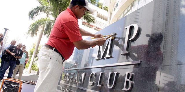 A worker removes the Trump name from the Trump Ocean Club International Hotel and Tower in Panama City, Panama March 5, 2018.