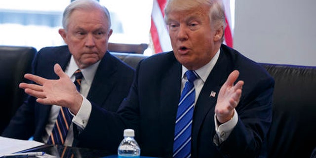 FILE - In this Oct. 7, 2016 file photo, then Sen. Jeff Sessions, R-Ala. listens at left as then-Republican presidential candidate Donald Trump speaks during a national security meeting with advisers at Trump Tower in New York.