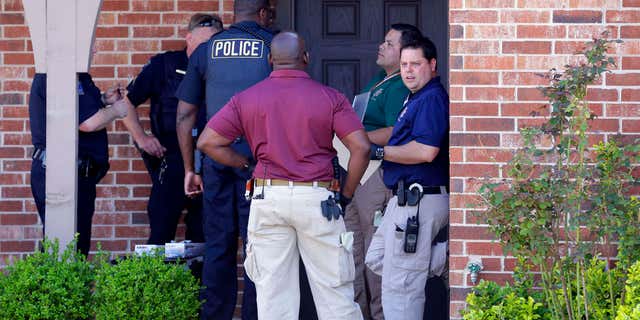 April 1, 2015: Tulsa police gather at the front entrance of a home as they investigate after the bodies of four people were found in Tulsa, Okla.