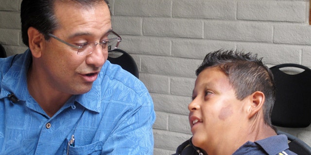 In this July 20, 2012, photo, Si Budagher, the pastor of First Baptist Church of Rio Rancho, N.M. speaks with 9-year-old Juarez, Mexico-born boy suffering from massive tumor who U.S. Homeland Security identified only as "Jose," at the First Baptist Church of Rio Rancho, N.M. His family says U.S. federal agents sent in an armored vehicle earlier in the week to their dangerous Juarez neighborhood to help transport the boy and his parents to Albuquerque, N.M. so the boy could receive treatment. (AP Photo/Russell Contreras)