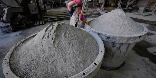 An employee controls the quality of tungsten concentrate at an ore-dressing mill at a Taiga settlement Vostok.