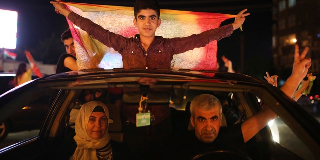 June 7, 2015: Supporters of the pro-Kurdish Peoples' Democratic Party (HDP) celebrate in Diyarbakir, southeastern Turkey. In a stunning rebuke of President Recep Tayyip Erdogan's ambitions to expand his powers, Turkish voters stripped his party of its simple majority in parliament, preliminary election results showed Sunday. (AP Photo/Emrah Tazegul)