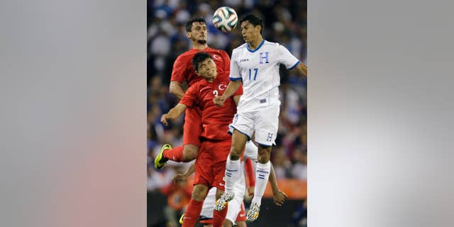 Turkey's Mustafa Pektemek, background, and Ishak Dogan (3) go up for the ball as Honduras’ Andy Najar (17) defends during the first half of an exhibition soccer game, Thursday, May 29, 2014, in Washington. (AP Photo/Luis M. Alvarez)