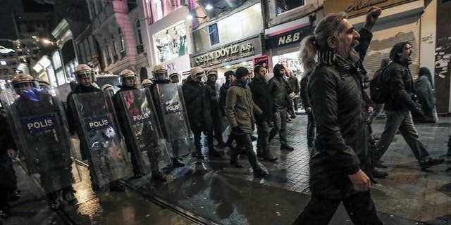 People protest the death of Berkin Elvan, a Turkish teenager who was in a coma since being hit in the head by a tear gas canister fired by police during the summer's anti-government protests, in Istanbul, Turkey, Tuesday, March 11, 2014. The 15-year old Berkin Elvan’s death in an Istanbul hospital _ nine months after he fell into a coma _ looked likely to spark new protests in Turkey. Riot police fired tear gas, water cannon and rubber bullets to disperse anti-government protesters trying to converge in central Ankara and Istanbul hours after Berkin Elvan’s family announced his death.(AP Photo/Emrah Gurel)