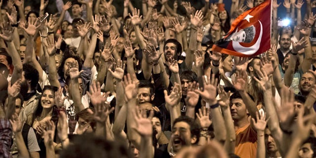 July 9, 2013: People celebrate on the steps leading to Gezi Park in Taksim square after Turkish riot police pulled back allowing them to enter the square in Istanbul, Turkey. Gezi Park remained open for the night after thousands of anti-government protesters broke their fast for the holy month of Ramadan by sitting down for a meal along a main Istanbul pedestrian street for a makeshift Ramadan banquet that stretched toward the city's landmark Taksim Square.