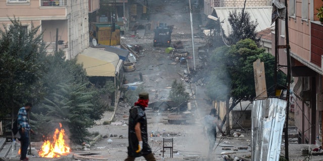 July 26, 2015 - Makeshift barricades fill the streets as left-wing protesters light a fire trying to avoid tear gas used by police to disperse them, in Istanbul, Sunday, during clashes between police and people protesting against Turkey's operation against Kurdish militants.