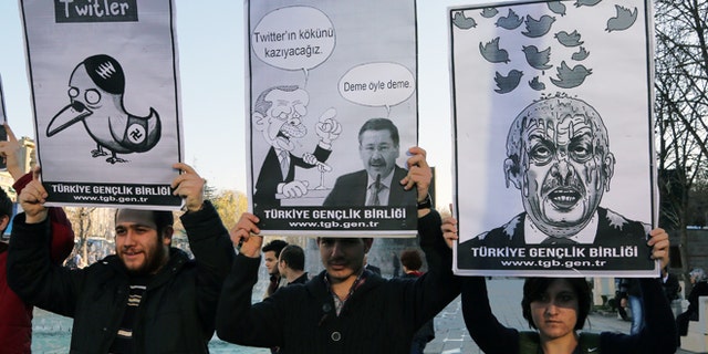 March 21, 2014: Members of the Turkish Youth Union hold cartoons depicting Turkey's Prime Minister Recep Tayyip Erdogan during a protest against a ban on Twitter, in Ankara, Turkey.
