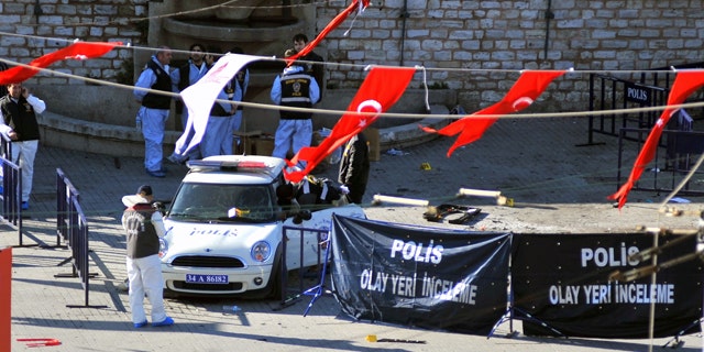 Police forensic officers inspect the scene after an explosion in Taksim square where riot police were stationed in case of demonstrations in Istanbul, Turkey, Sunday, Oct. 31, 2010. A suspected suicide bomber detonated a device in Istanbul's main square on Sunday, wounding 32 people, Istanbul's police chief said.