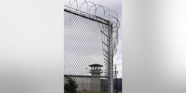 FILE - In this Tuesday, Sept. 24, 2013 file photo, razor wire and towers contain the Julia Tutwiler Prison for Women, in Wetumpka, Ala. In January 2014, the U.S. Department of Justice issued a scathing report that put a spotlight on what it called conditions of sexual abuse and harassment by correctional staff at the Alabama’s only prison for women. State officials vehemently disagree with the federal assessment. (AP Photo/Dave Martin, File)