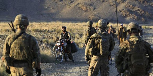 October 2: U.S. soldiers from Alpha Co, 2nd Battalion 35th Infantry, Task Force "Cacti" and Afghan soldiers check villagers along a road during a joint military patrol in Walay valley, near the Afghanistan-Pakistanborder in Kunar province.