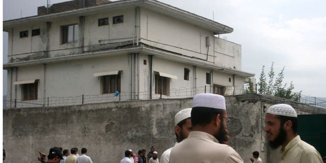 In this May 5, 2011 file photo, local residents and media are seen outside the house where Al Qaeda leader Usama bin Laden was caught and killed in Abbottabad, Pakistan.