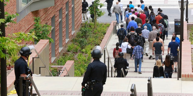 Los Angeles Police officers escort people at the UCLA campus after a fatal shooting at the University of California, Los Angeles, Wednesday, June 1, 2016, in Los Angeles. Los Angeles police chief says shooting at UCLA was murder-suicide. (AP Photo/Damian Dovarganes)