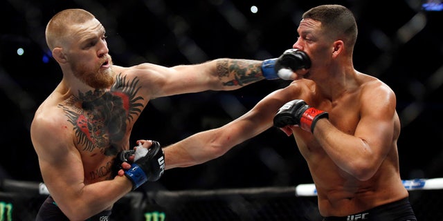 Conor McGregor, left, punches Nate Diaz during their welterweight mixed martial arts bout at UFC 202 on Saturday, Aug. 20, 2016, in Las Vegas. McGregor won by split decision. (AP Photo/Isaac Brekken)