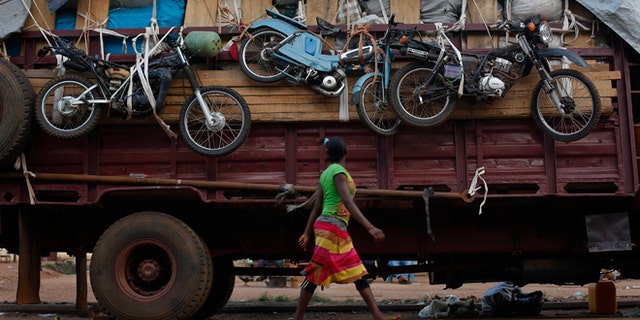 April 9, 2014: A woman walks past a truck waiting to leave for Chad loaded with goods belonging to Muslim residents of the PK5 district of Bangui, Central African Republic.