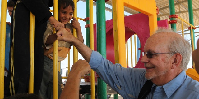 Executive Director of the United Nations Children's Fund (UNICEF) Anthony Lake smiles as he fist bumps with Syrian children during a visit to the Al Zaatri refugee camp, in the Jordanian city of Mafraq, near the border with Syria.