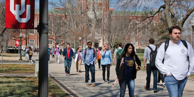 People walk on the Oval at the University of Oklahoma in Norman, Okla., Tuesday, March 10, 2015.