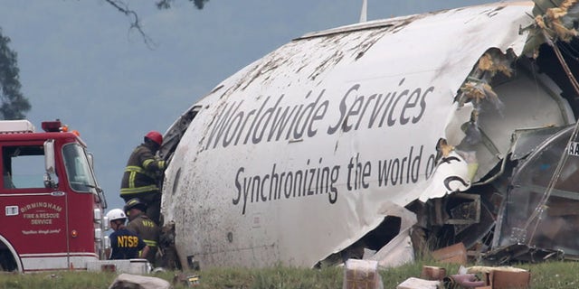 Aug. 14, 2013: Investigators work near a section of debris of a UPS Airbus A300 cargo plane after it crashed on approach at Birmingham-Shuttlesworth International Airport in Birmingham, Ala.