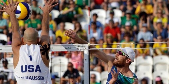 Brazil's Alison Cerutti, right, hits over United States' Phil Dalhausser during a men's beach volleyball quarterfinal match at the 2016 Summer Olympics in Rio de Janeiro, Brazil, Monday, Aug. 15, 2016. (AP Photo/Marcio Jose Sanchez)
