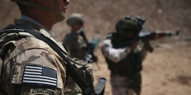 TAJI, IRAQ - APRIL 12: U.S. Army trainers watch as an Iraqi recruit fires at a military base on April 12, 2015 in Taji, Iraq. U.S. forces, currently operating in 5 large bases throught the country, are training thousands of Iraqi Army combat troops, trying to rebuild a force they had origninally trained before the U.S. withdrawal from Iraq in 2010. Members of the U.S. Army's 5-73 CAV, 3BCT, 82nd Airborne Division are teaching members of the newly-formed 15th Division of the Iraqi Army, as the Iraqi government launches offensives to try to recover territory lost to ISIS last year. (Photo by John Moore/Getty Images)