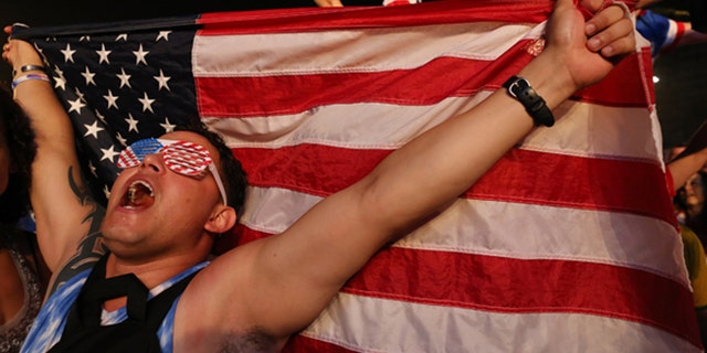 A soccer fan of the U.S. national soccer team celebrates his team's victory during a live broadcast of the soccer World Cup match between the Unites States and Ghana, inside the FIFA Fan Fest area on Copacabana beach, Rio de Janeiro, Brazil, Monday, June 16, 2014. Clint Dempsey scored in the first minute and rookie substitute John Brooks scored a late game winner as the U.S. defeated Ghana 2-1 in the World Cup opener for both. (AP Photo/Leo Correa)