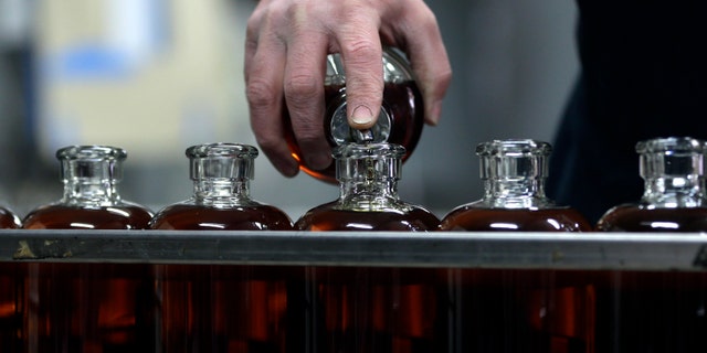 Distilleryman Brian Messina tops off bottles of baby bourbon on the bottling line at Tuthilltown Spirits.