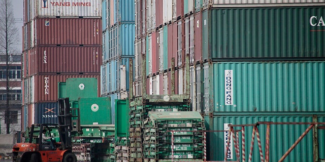 FILE - In this file photo taken March 2, 2011, a forklift arranges the shipping containers near a port in Shanghai. U.S. manufacturers have grown more competitive over the past decade compared with factories in China, Brazil and most of the world's other major economies. So says a new private study issuing a report Friday April 25, 2014, which found that rising wages and higher energy costs have diminished China's long-standing edge over the United States. (AP Photo/Eugene Hoshiko, File)