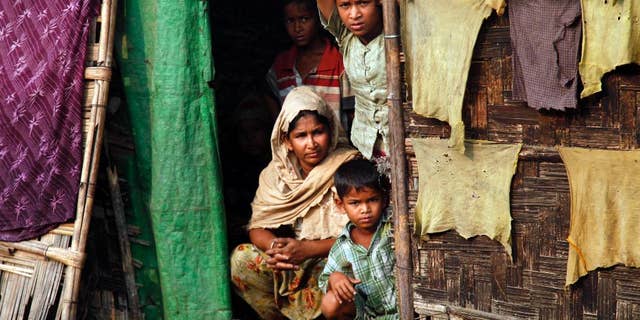 In this April 2, 2014, photo, a Myanmar Muslim family, who identify themselves as long-persecuted "Rohingya" Muslims, look out from their tents at Da Paing camp for Muslim refugees in north of Sittwe, Rakhine State, western Myanmar. Two years after the United States announced the normalization of diplomatic relations with Myanmar, optimism in Washington over the nation’s embrace of democracy is waning and concern over the plight of minority Muslims is growing. (AP Photo/Khin Maung Win)