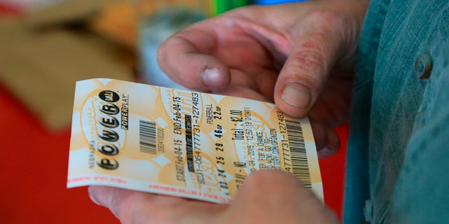 Feb. 4, 2015: A customer inspects the Powerball ticket she purchased at a U-Stop store in Lincoln, Neb.