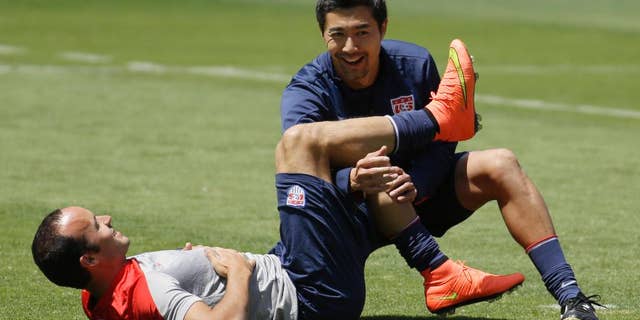 United States forward Landon Donovan stretches with assistance from a trainer in preparation for the World Cup soccer tournament on Thursday, May 22, 2014, in Stanford, Calif. (AP Photo/Ben Margot)