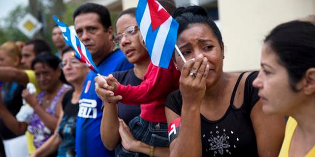 A woman weeps after watching the ashes of Cuban leader Fidel Castro along the main road in Baire, eastern Cuba, Saturday, Dec. 3, 2016. The convoy is on the last stage of a four-day journey across Cuba through small towns and cities where his rebel army fought its way to power nearly 60 years ago, to the eastern city of Santiago, where his remains will be interred on Sunday. (AP Photo/Rodrigo Abd)