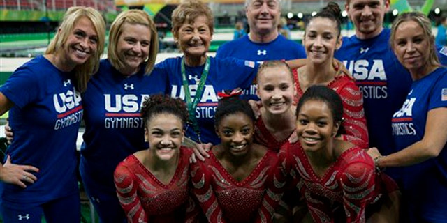 The United States women's gymnastic team poses for a picture with their coaching staff after finishing podium training ahead of the 2016 Summer Olympics in Rio de Janeiro, Brazil, Thursday, Aug. 4, 2016. Front row, from left, are gymnasts Lauren Hernandez, Simone Biles, and Gabby Douglas. Behind them are Madison Kocian, left, and Alexandra Raisman. Head coach Martha Karolyi is back row, third from left.(AP Photo/Rebecca Blackwell)