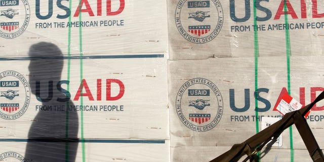 A shadow is cast on boxes of relief items from U.S. Agency for International Development (USAID).
