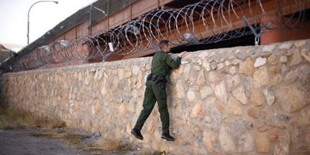 A United States Border Patrol agent checks an area under a bridge crossing between the United States and Mexico in El Paso, Texas November 14, 2010. El Paso lies across the border from Ciudad Juarez, Mexico, a violent city on the frontlines of Mexico's war against drug cartels. Picture taken November 14, 2010.