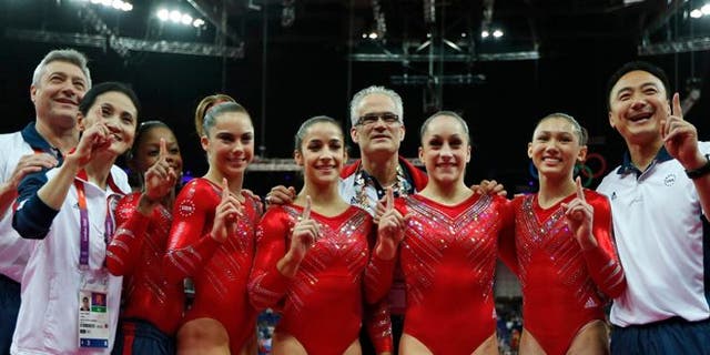 July 31, 2012: U.S. gymnasts, left to right wearing red, Gabrielle Douglas, McKayla Maroney, Alexandra Raisman, Jordyn Wieber and Kyla Ross celebrate with coaches Jenny Zhang, front left, Mihai Brestyan, back left, John Geddert, center, and Liang Chow, right, after their team won the gold medal for the Artistic Gymnastics women's team final at the 2012 Summer Olympics, in London.