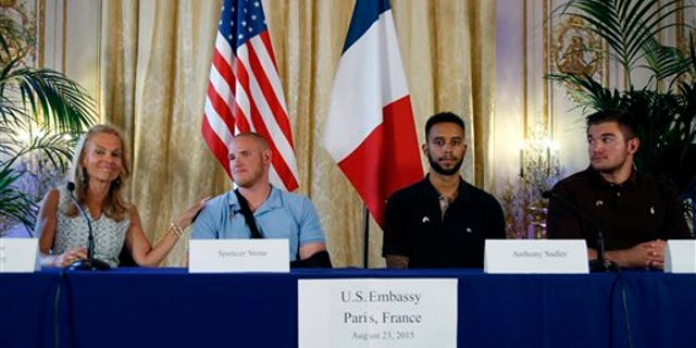 From left, U.S. Ambassador to France Jane D. Hartley, U.S. Airman Spencer Stone, Anthony Sadler, and National Guardsman Alek Skarlatos at press conference in Paris, France, Sunday, Aug. 23, 2015.. (AP Photo/Francois Mori)