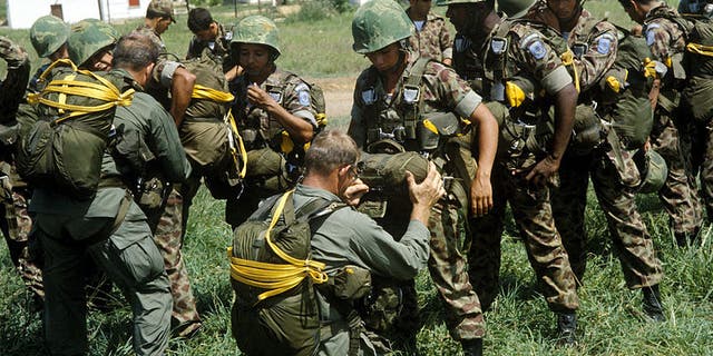 U.S. Army soldiers check the equipment of Colombian paratroopers. (Photo: Department of Defense)