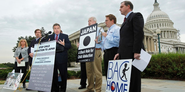 Sept. 29, 2010: In this file photo, Rep. Chris Smith, center, R-N.J. with relatives of American children abducted to Japan, speaks at a news conference on Capitol Hill in Washington, calling for swift passage of a resolution on child abduction to Japan. Japan has taken the first step toward joining an international child custody convention Thursday, May 19, 2011 amid foreign pressure on Tokyo to revise a policy some say allows Japanese mothers to too easily take their children away from foreign fathers.