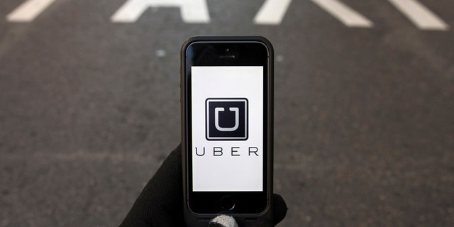 File photo - The logo of car-sharing service app Uber on a smartphone over a reserved lane for taxis in a street is seen in this photo illustration taken in Madrid on Dec. 10, 2014.