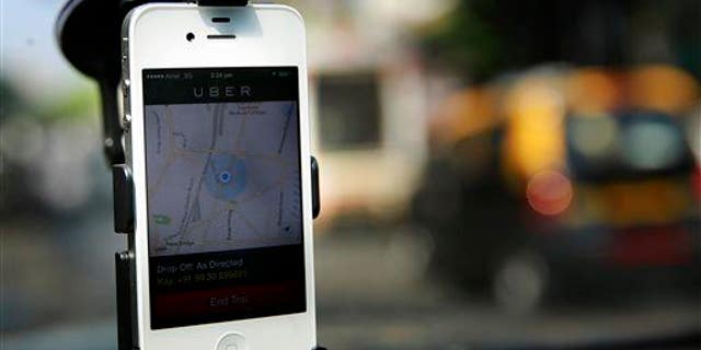 In this 2014 photo, a smartphone is mounted on the glass of an Uber car in Mumbai, India.
