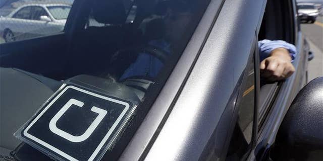 An Uber driver sits in his car near the San Francisco International Airport.