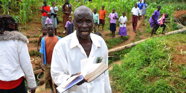 June 26, 2012: A man holding a bible cries out for God's mercy at the landslide in Bududa, about 250km east of Uganda capital Kampala.