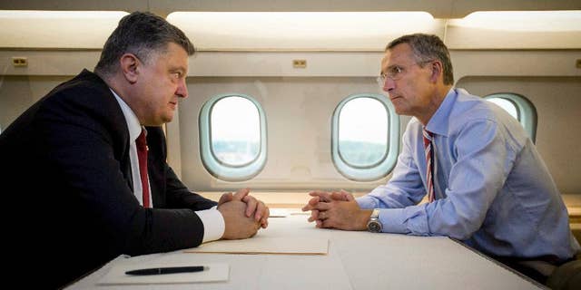 Ukrainian President Petro Poroshenko, left, and NATO Secretary General Jens Stoltenberg talk in a helicopter on the way to a military training ground outside Lviv, western Ukraine, Monday, Sept. 21, 2015. Stoltenberg arrived in Ukraine for NATO-Ukraine joint exercises. (Mikhail Palinchak, Pool Photo via AP )