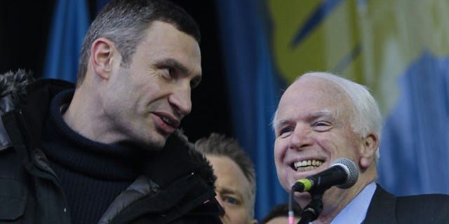 December 15, 2013: Ukrainian lawmaker and chairman of the Ukrainian opposition party Udar (Punch), WBC heavyweight boxing champion Vitali Klitschko, left, speaks to U.S. Senator John McCain during a pro-European Union rally in Independence Square in Kiev, Ukraine. (AP Photo)