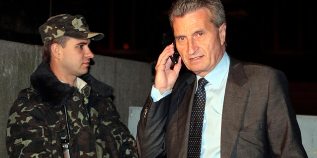 June 15, 2014: European Union energy chief Guenther Oetinger talks on the phone outside the government building in Kiev, Ukraine. (AP Photo/Sergei Chuzavkov)