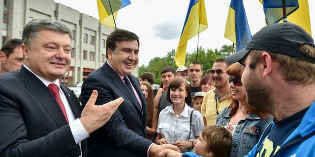 2015年5月30日星期六，在乌克兰敖德萨，公民向乌克兰总统彼得罗·波罗申科（左）和新任命的敖德萨地区州长米哈伊尔·萨卡什维利（左二）致意。