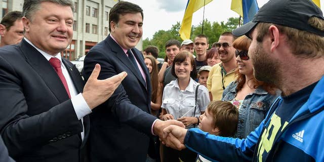 Former Georgian President Saakashvili describes how he tried to warn the West about Russia 3 Citizens greet Ukrainian President Petro Poroshenko, left, and Mikhail Saakashvili, second left, the new governor of the Odessa region, in Odessa, Ukraine, Saturday, May 30, 2015.