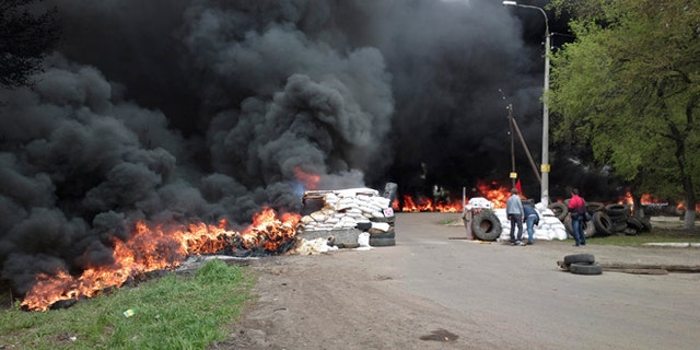 April 24, 2014: Black smoke billows from burning tires at a checkpoint following an attack by Ukrainian troops outside Slovyansk, Ukraine.